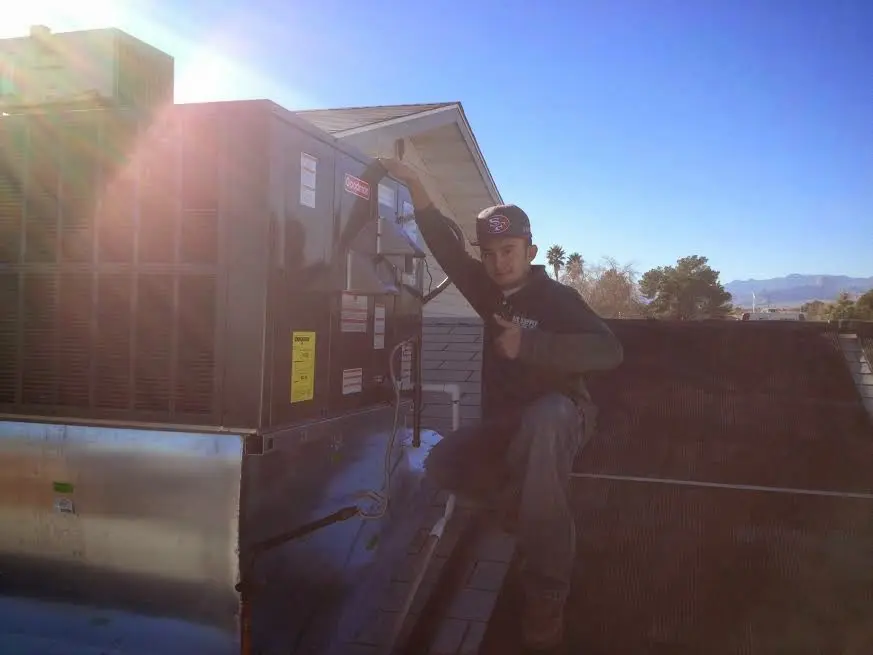 HVAC technician performing Air Duct Cleaning on a rooftop unit in Batesville